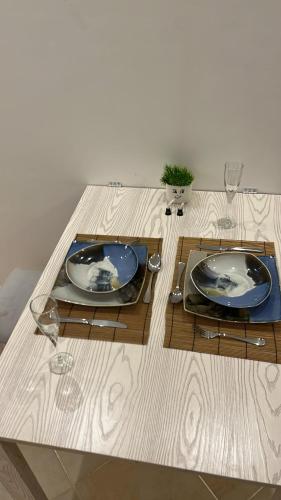 a table with two plates and wine glasses on it at Binishty hurghada apartment in Hurghada