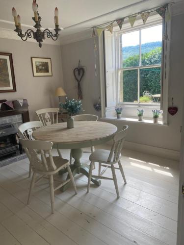 uma sala de jantar com uma mesa e cadeiras e uma janela em Bewerley Hall farm em Harrogate