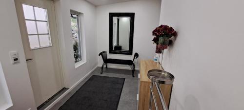 a hallway with a table and a chair and a mirror at Bergen Sunrise Terrace Apartment in Bergen