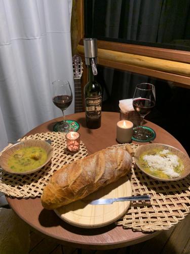 a table with a plate of bread and two glasses of wine at Montanha Home in Monte Verde