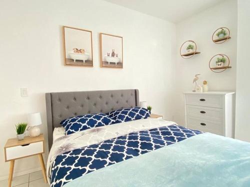 Un dormitorio con una cama azul y blanca y un tocador en MIAMI BEACH HOME NEAR THE OCEAN, en Miami Beach