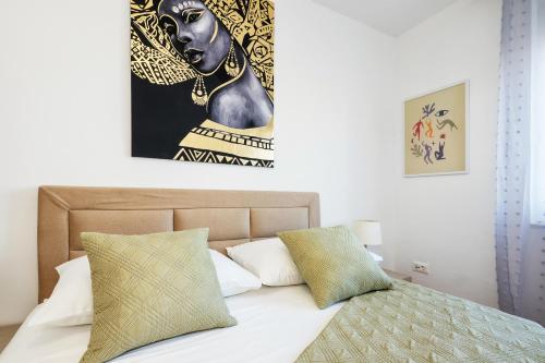 a bedroom with a bed with a painting on the wall at Split Serenity/ Suite with Sea View Balcony in Split