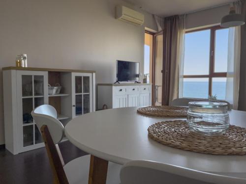 een witte eetkamer met een tafel en stoelen bij Cabacum Beach Residence AP.20 in Varna