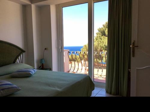 a bedroom with a bed and a large sliding glass door at spettacolare suite Tragara Capri in Capri