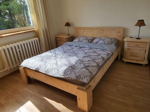 a bedroom with a wooden bed and two night stands at Na Dębowej- Apartament/dom 2 pokoje-prywatny las in Szczytna