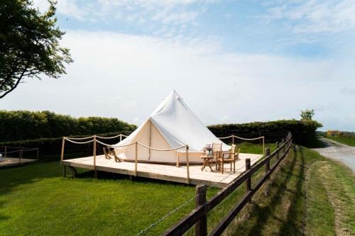 a white tent with a table on a field at Hafod Hir in Cross Inn