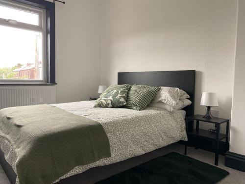 a white bedroom with a bed and a window at 3 bed house Hyde near Manchester in Hyde