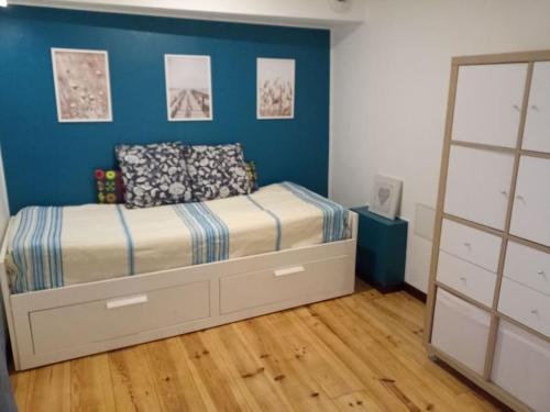 Schlafzimmer mit einem Bett mit blauer Wand in der Unterkunft Cosy petit appartement in Gignac