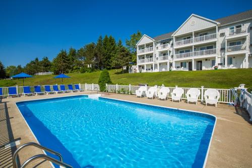 a swimming pool in front of a resort at Strawberry Hill Seaside Inn in Rockport