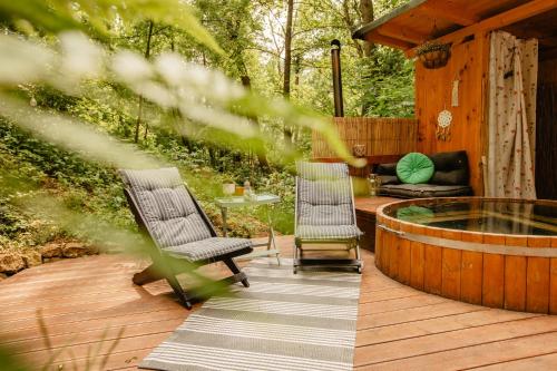 a deck with two chairs and a hot tub at Yurt in the Wood 