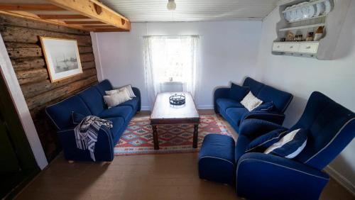 a living room with two blue couches and a table at Real fisherman's cabins in Ballstad, Lofoten in Ballstad