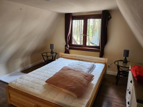 Bett in einem Zimmer mit Fenster in der Unterkunft Jak Tu Sielsko in Osiek