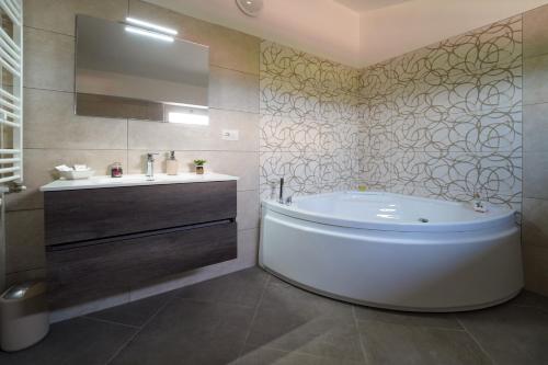 a bathroom with a large tub and a sink at Villa Falcone in Alvignano
