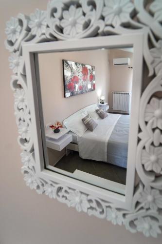 a bedroom with a white bed and a mirror at Villa Falcone in Alvignano