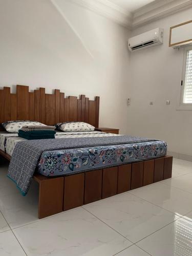 a bed in a room with a wooden head board at Appartement Luxueux vu sur mer à 50 mètres de la plage in Sali Tapé