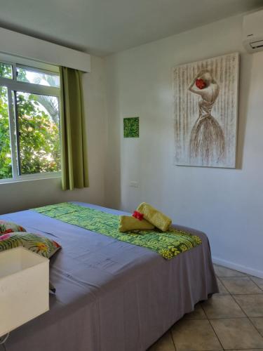 a bedroom with two beds and a picture of a bird on the wall at Pension ANAPA LODGE - MOOREA in Vaianae