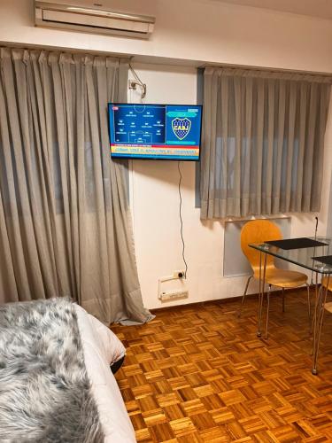 Habitación con TV, mesa y cama. en Esme en Buenos Aires