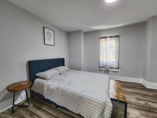 Schlafzimmer mit einem Bett, einem Tisch und einem Fenster in der Unterkunft Tastefully furnished repose home in Springfield