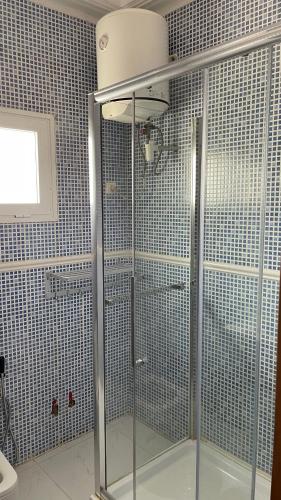 a shower with a glass door in a bathroom at Appartement Luxueux En Résidence vu sur mer à 50 mètres de la plage in Sali Tapé