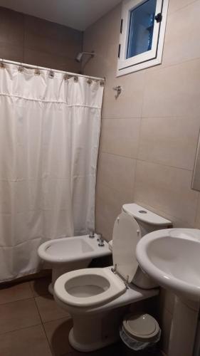 a bathroom with a white toilet and a sink at Monoambiente San Isidro in San Juan