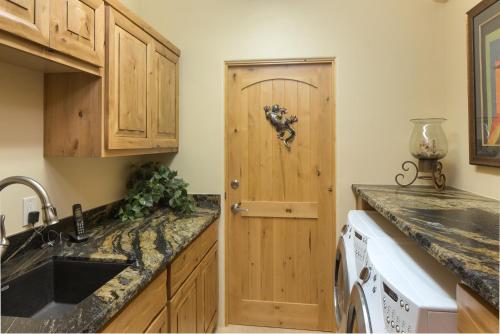 a kitchen with a sink and a wooden door at Palatial Paradise with Breathtaking Views of Red Rock and Stunning Infinity Pool in Sedona