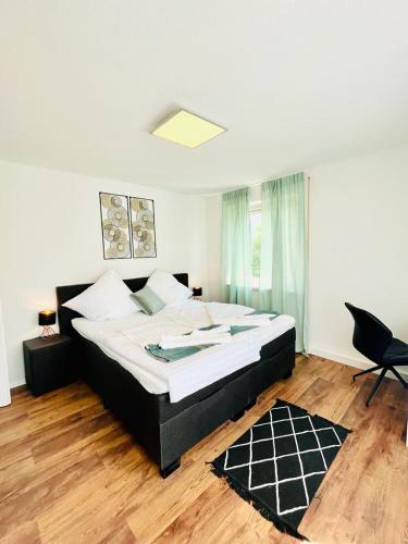 um quarto com uma cama grande e uma cadeira em 3Room-Central-Modern- The Seashell by SA-Grandeur em Friedrichshafen