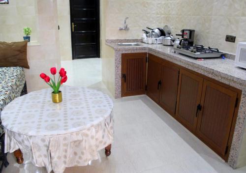 a kitchen with a table with a vase of flowers on it at Résidence Miramare Marrakech in Marrakech