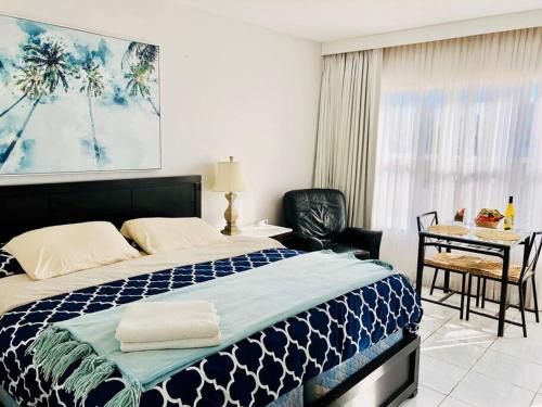 a bedroom with a bed and a desk with a chair at APARTMENT RIGHT ON THE BEACH! in Miami Beach