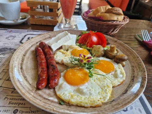 a plate of breakfast food with eggs sausage and bread at Villa 1927 in Belgrade