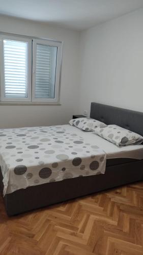 a large bed in a bedroom with a wooden floor at New Ursic App 4+2 in Brela