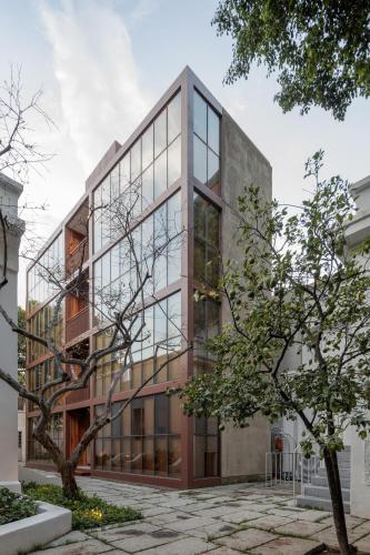 an office building with glass windows and a tree at Casa Bosque Eduviges in Guadalajara