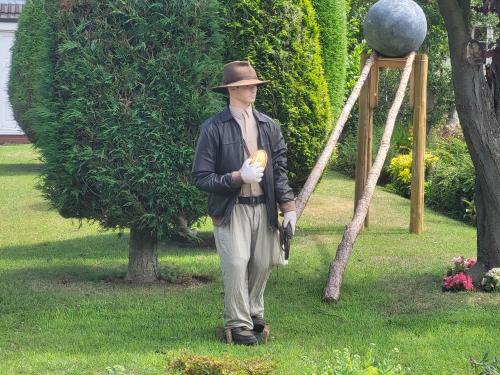 a man in a hat is holding a banana at Almost Heaven in Acton Trussell