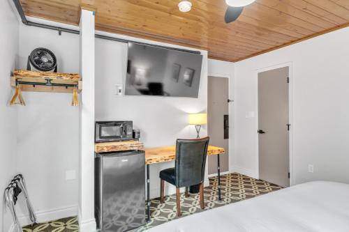 um quarto com uma cama, uma secretária e uma televisão em Highliner Hotel - Deluxe King with City View em Anchorage