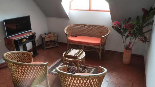 a living room with a chair and a television at Finca Turistica Rural El Descanso, privada Restrepo, Meta - Colombia in Restrepo