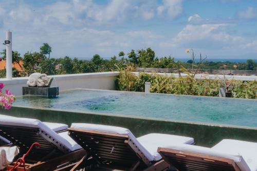 a swimming pool with lounge chairs and a swimming pool at Allia Residence in Nusa Dua