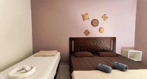 een slaapkamer met 2 bedden en een hoofdeinde bij Casa Janga Mar in Barra de São Miguel