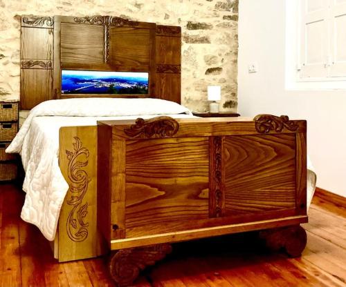 a large wooden bed with a wooden headboard in a bedroom at Loft Porta da Vila in Noya