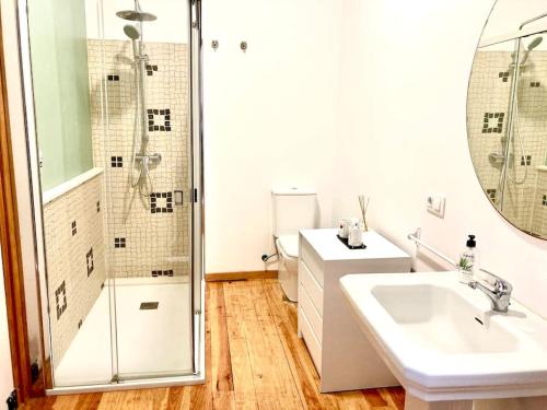 a white bathroom with a shower and a sink at Loft Porta da Vila in Noya
