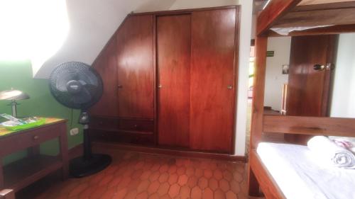 a bedroom with a wooden cabinet and a fan at Finca Turistica Rural El Descanso, privada Restrepo, Meta - Colombia in Restrepo