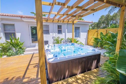 a hot tub in a backyard with a pergola at HOUSE WITH A HOT TUB ! ONLY 10 MINS TO THE BEACH in Biscayne Park