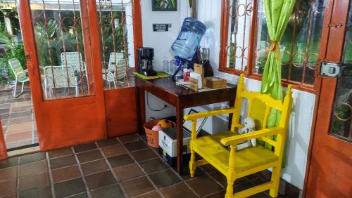a room with a desk and two yellow chairs at Finca Turistica Rural El Descanso, privada Restrepo, Meta - Colombia in Restrepo