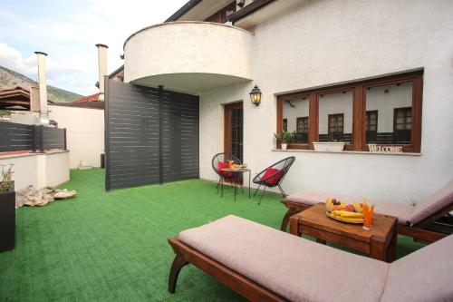 a patio with green grass and a table and chairs at Hotel Emen in Mostar