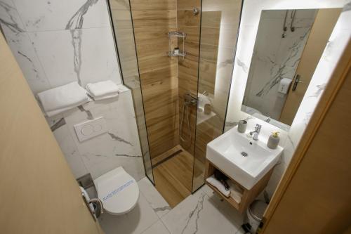 a bathroom with a shower and a toilet and a sink at Hotel Emen in Mostar