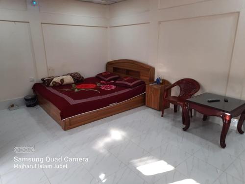 Sunapur Mini Resort Sylhet في سيلهيت: غرفة نوم بسرير وطاولة وكرسي