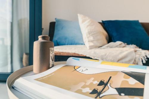 einen Tisch mit einem Buch und einer Flasche darauf in der Unterkunft BNBNRD Stylish Boutique Apartment 45m2 w Panoramic Views - private entrance in Amsterdam