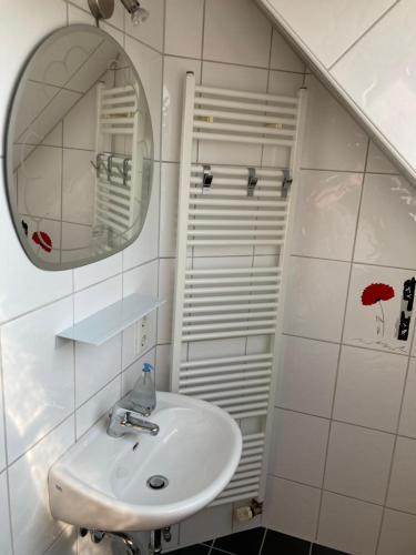 een witte badkamer met een wastafel en een spiegel bij Ferienwohnung Gottlieb Extertal Bösingfeld Erholung für 5 Personen in Extertal