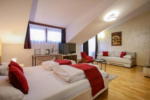 a bedroom with two beds and a living room at Hotel Emen in Mostar