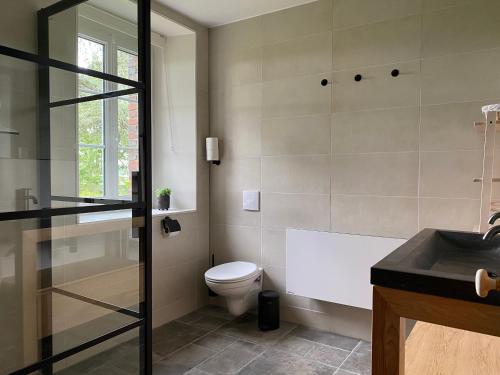 ein Badezimmer mit einer Badewanne, einem WC und einem Waschbecken in der Unterkunft Le Moulin du Saon in Saon