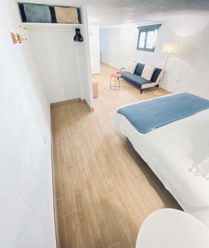 a bedroom with a bed and a couch in a room at Casa Gercko 1 in Yaiza