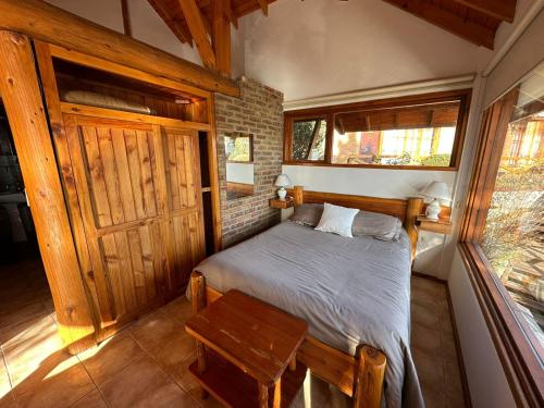 a bedroom with a bed and a wooden door at Ruca Nehuen in San Carlos de Bariloche